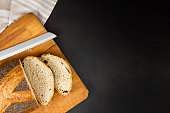 Sliced fresh whole wheat bread on a black background.