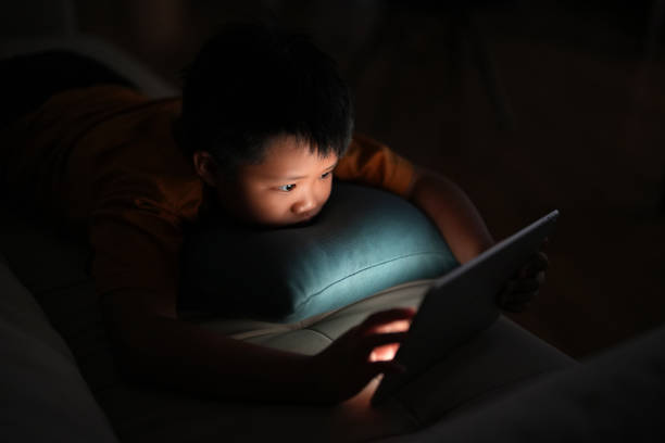 istock High angle view a young boy using a digital tablet at home at nighttime 1469204427