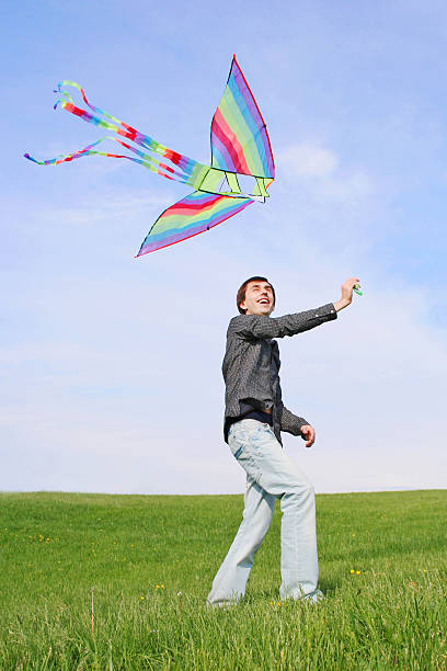 istock young man flying multicolored kite at summer time 146920545