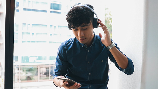 Young Man Listening To Music using Mobile App