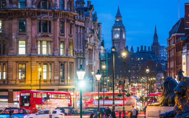 London Big Ben overlooking Whitehall red buses Trafalgar Square night stock photo