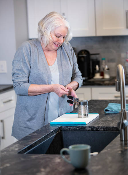 istock Senior woman with arthritis tries to use can opener 1469208049