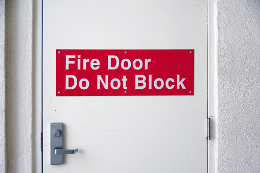 FIRE DOOR DO NOT BLOCK signage on a fire safety exit door