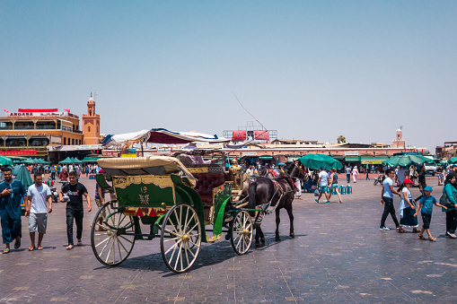 Marrakesh, Morocco - July 25th 2018 : view of horse-drawn carriage tour in Jemaa el Fna square