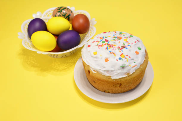 istock A cake with white icing and a basket of easter eggs on a yellow background 1469212739