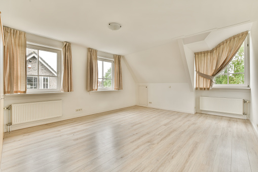 Cozy interior design of living room furnished with wooden table decorated in modern attic apartment with beige walls