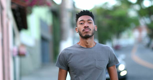 istock Young black man standing outside looking at camera. Mixed race guy ethnicity 1469215777