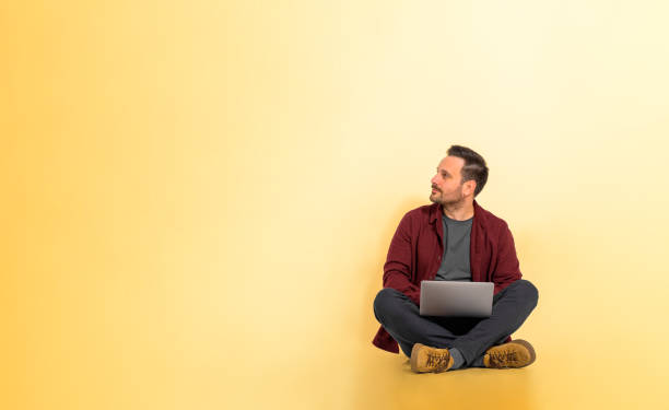 istock Businessman working on laptop over yellow background 1469217526