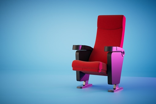 the concept of going to the cinema. the chair in the cinema is red on a blue background. 3D render.