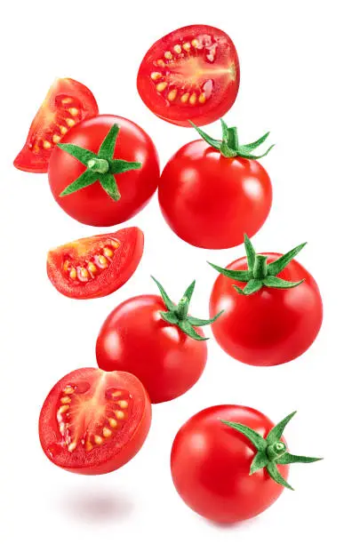 Photo of Falling cherry tomatoes and tomato slices isolated on white background. Macro shot. File contains clipping paths for each item.