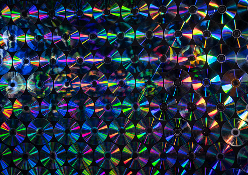 Textured background of large group of multicolored CDs