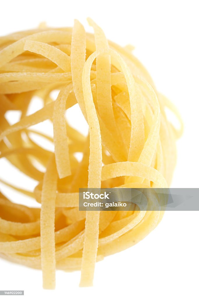 Pasta - cut them. One of pieces of pasta - tagliatele. Close-up. The background is blurred. Isolated on white background. Cereal Plant Stock Photo