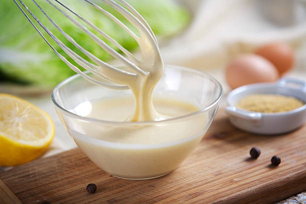 Homemade mayonnaise being whipped in a glass bowl Preparation of mayonnaise in the home kitchen on a sunny day mayonnaise photos stock pictures, royalty-free photos & images
