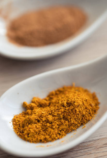 istock Two spoons with spices seen up close. Cinnamon and Indian curry 1469225404