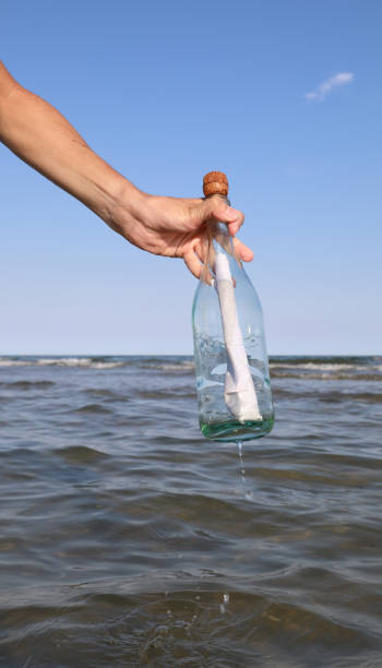 istock hand takes a bottle with secret message inside 1469230927