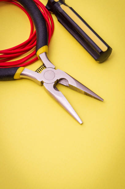 istock Electrician's tools and wire on yellow background for repairing energized systems or communications 1469236172