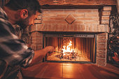 Young man light a fireplace at home