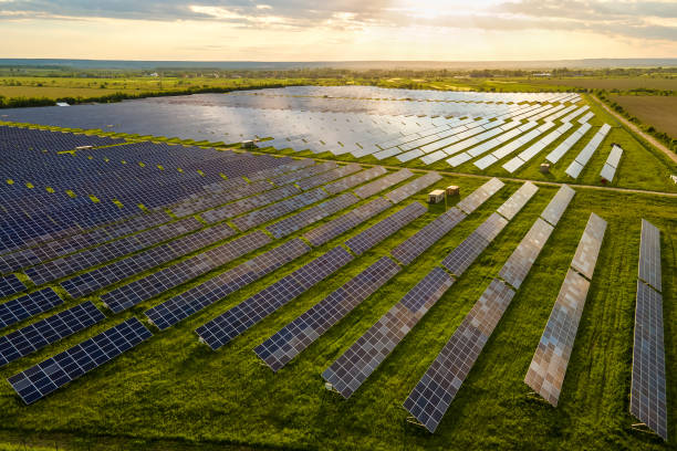 vista aérea de una gran planta de energía eléctrica sostenible con muchas filas de paneles solares fotovoltaicos para energía eléctrica ecológica limpia al amanecer. electricidad renovable con concepto de cero emisiones. - música industrial fotografías e imágenes de stock