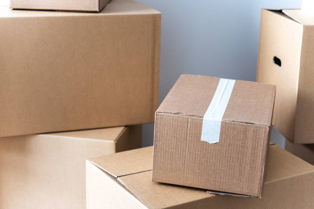 istock Stack of cardboard boxes at at the white wall. Moving home concept 1469245532