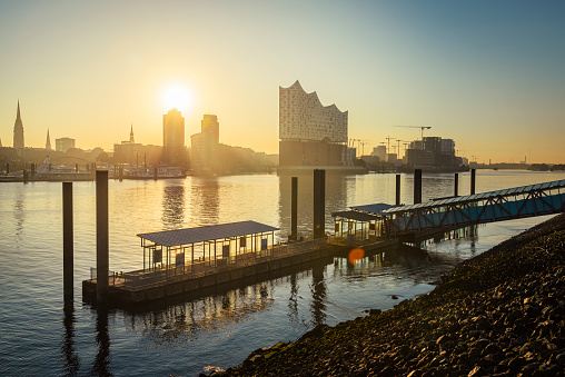 Sunrise at the Elbphilharmonie, Hafencity and a ferry pier in the river Elbe in Hamburg harbour, Germany