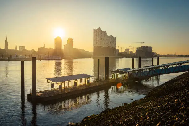 Sunrise at the Elbphilharmonie, Hafencity and a ferry pier in the river Elbe in Hamburg harbour, Germany