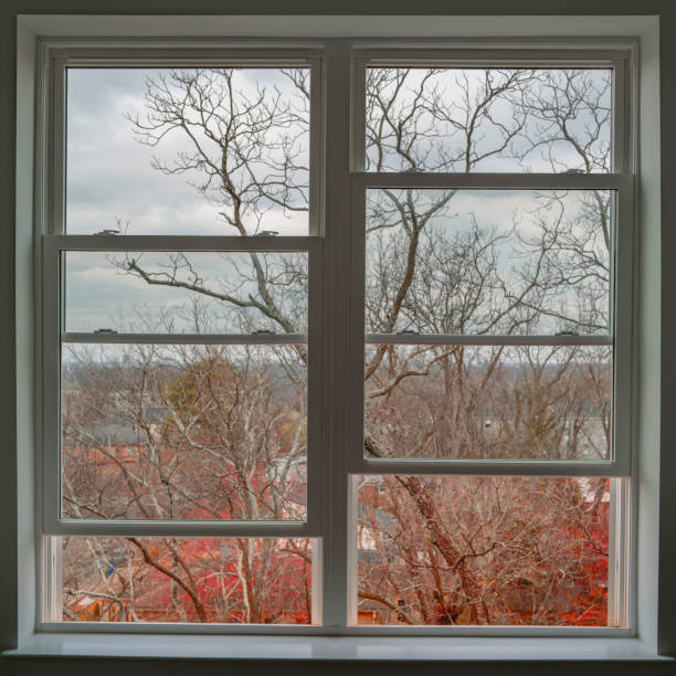 istock Square shape interior window frame with the view of red spring sprouts of barren maple tree branches of city outdoors, selective focus on the foreground 1469249136