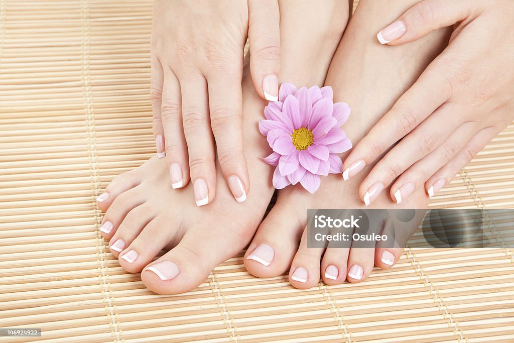 Female hands and feet with manicured nails and lotus flower care for beautiful woman legs Adult Stock Photo