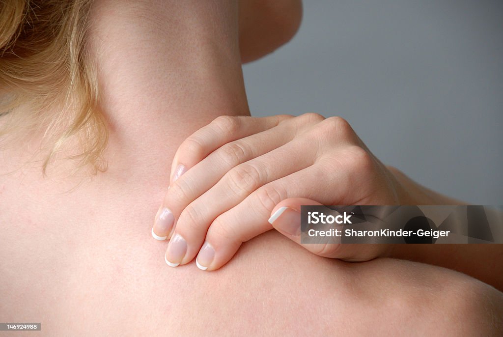 Neckache Female model massaging her neck/shoulder Females Stock Photo