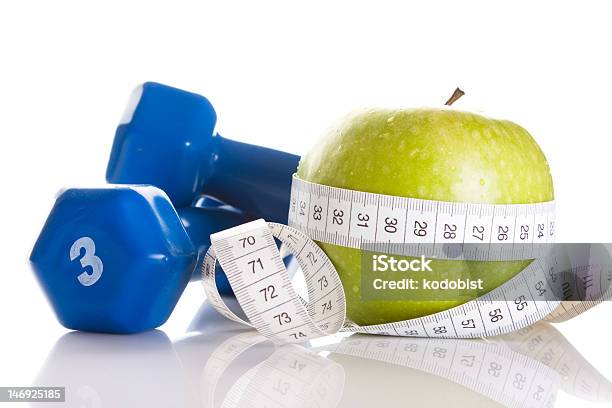 Dumbbells With Green Apple And Measuring Tape On White Stock Photo - Download Image Now