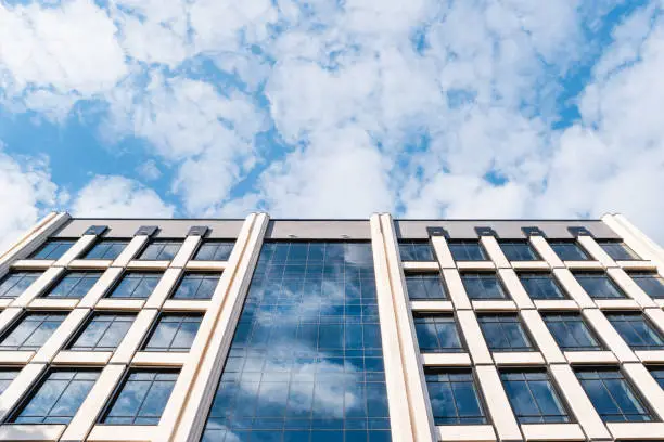 Bottom view on building of business-centre on blue sky background. Modern architecture.