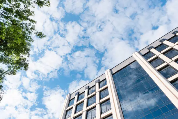 Bottom view on building of business-centre on blue sky background. Modern architecture.