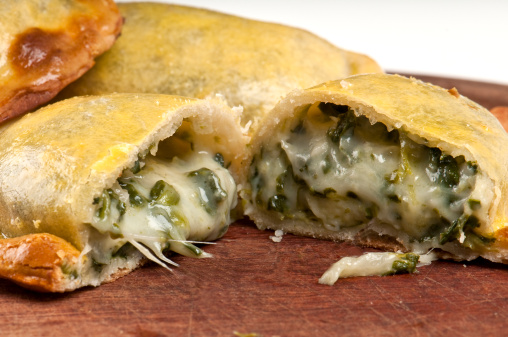 Spinach empanada fill close up.  The Empanada is a pastry turnover filled with a variety of savory ingredients and baked or fried.