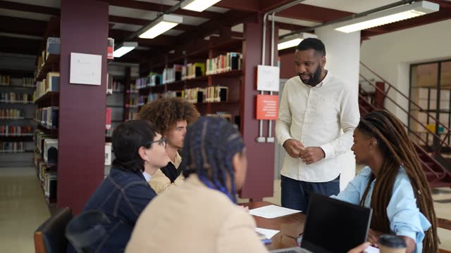 Teacher talking to students in the library