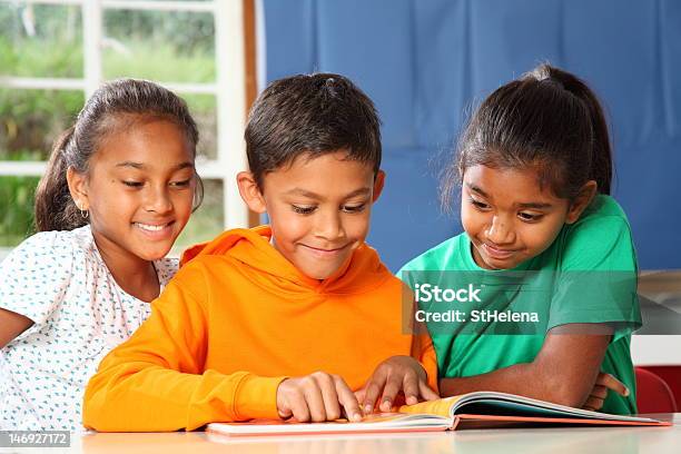 Tre Principali Scuola Bambini Nella Classe Di Apprendimento E Lettura Insieme - Fotografie stock e altre immagini di Aula