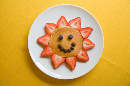 pancake and berries arranged in a smiley face