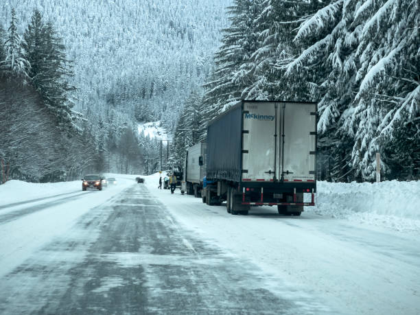 szeroki widok pojazdów zakładających łańcuchy na opony zimowe na poboczu drogi podczas zaśnieżonych warunków. - north cascades national park cascade range highway north zdjęcia i obrazy z banku zdjęć