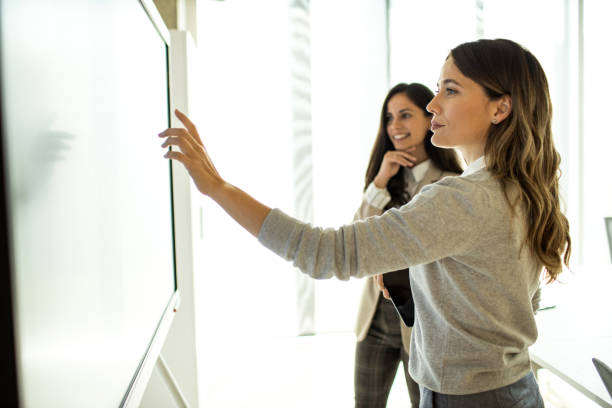 istock Businesswoman showing financial data on touchscreen smart television 1469289941