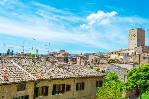 Photo of San Gimignano under a blue sky with clouds