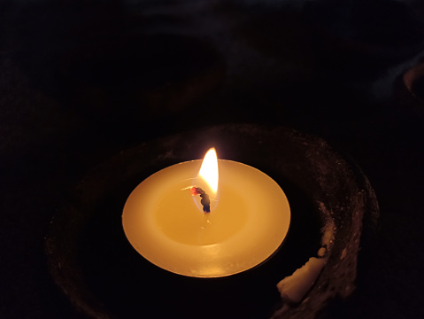 One candle light in the night on dark background. Light of candles backgrounds.