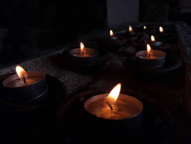 luci di candela nella notte su sfondo scuro. luce degli sfondi delle candele. - church altar indoors dark foto e immagini stock