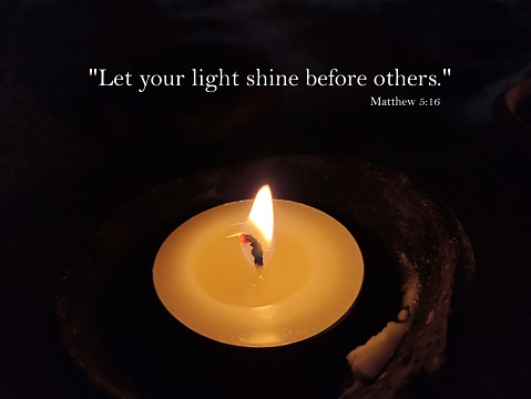Bible verse quote - Let your light shines before others. Matthew 5:16. With one candle light in the night on dark background. Christianity concept.
