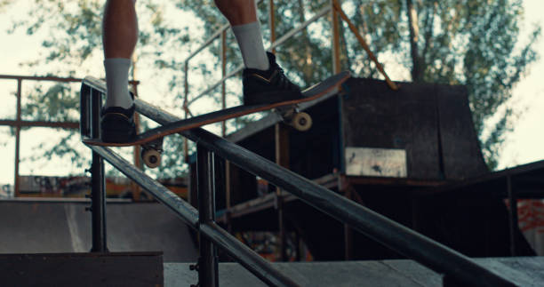 활동적인 십대 스케이터는 도시 스케이트 공원에서 스케이트 보드로 레일에 뛰어 오른다. - railing beautiful human leg people 뉴스 사진 이미지