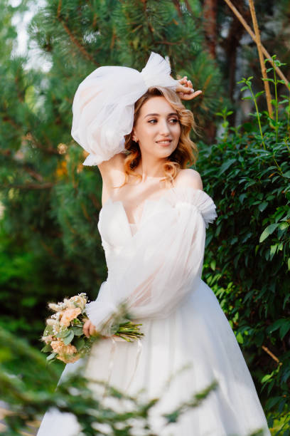 istock a bride in an open-shouldered dress poses against the backdrop of greenery 1469307751