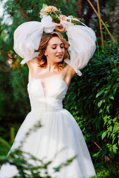 istock a bride in an open-shouldered dress poses against the backdrop of greenery 1469307791
