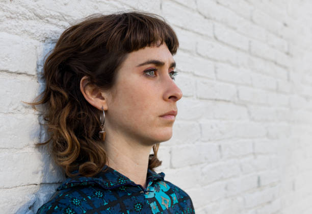 istock mullet hairstyle woman looking serious at something with her green eyes while has her back on a white brick wall 1469314503