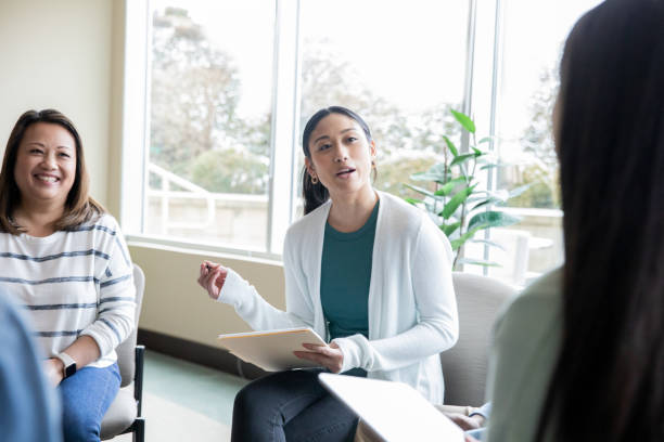 istock Young woman leads discussion during group meeting or therapy session 1469314594