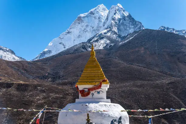 Photo of An ancient Tibetan Buddhist stupa with beautiful view of Mt.Ama Dablam view from Dingboche village in rural Nepal.