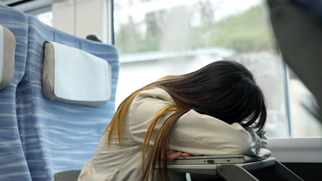 4K Asian woman napping on train.