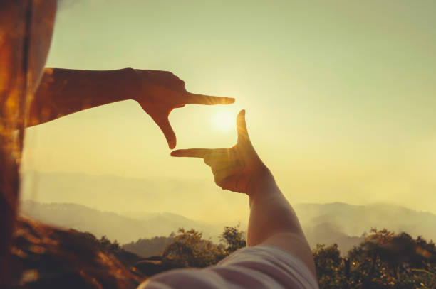 istock close up hand framing looking view sunrise 1469326173