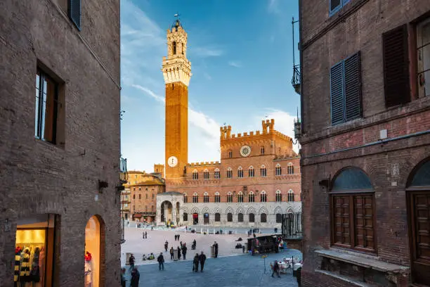 Piazza del Campo with the historic Palazzo Pubblico and Torre del Mangia in downtown Siena, Tuscany, Italy.